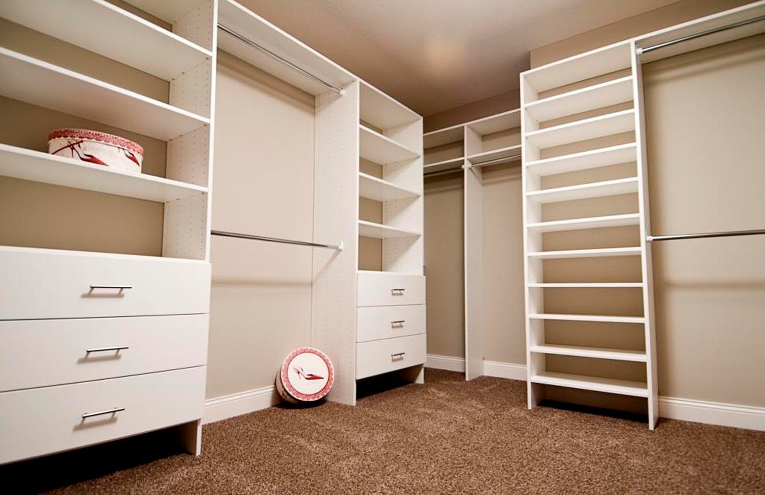 a walk in closet with lots of shelves and drawers