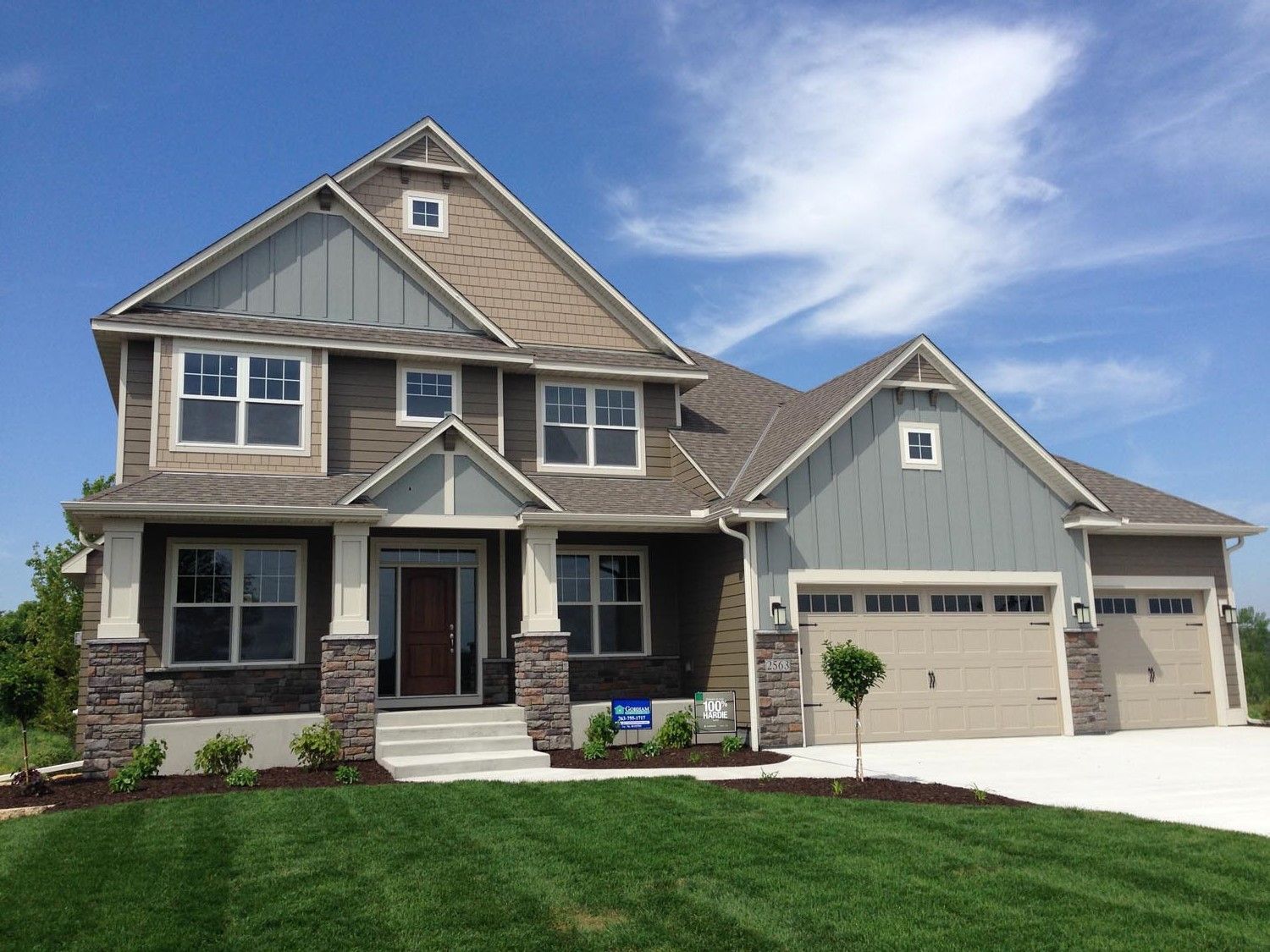 a large house with a lot of windows and garage doors