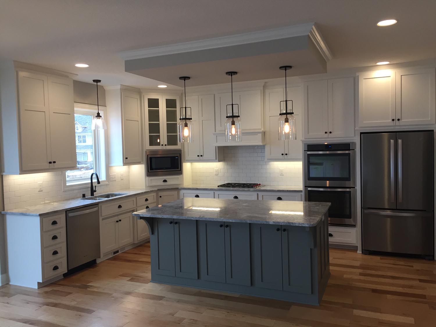 a kitchen with white cabinets and a large island in the middle