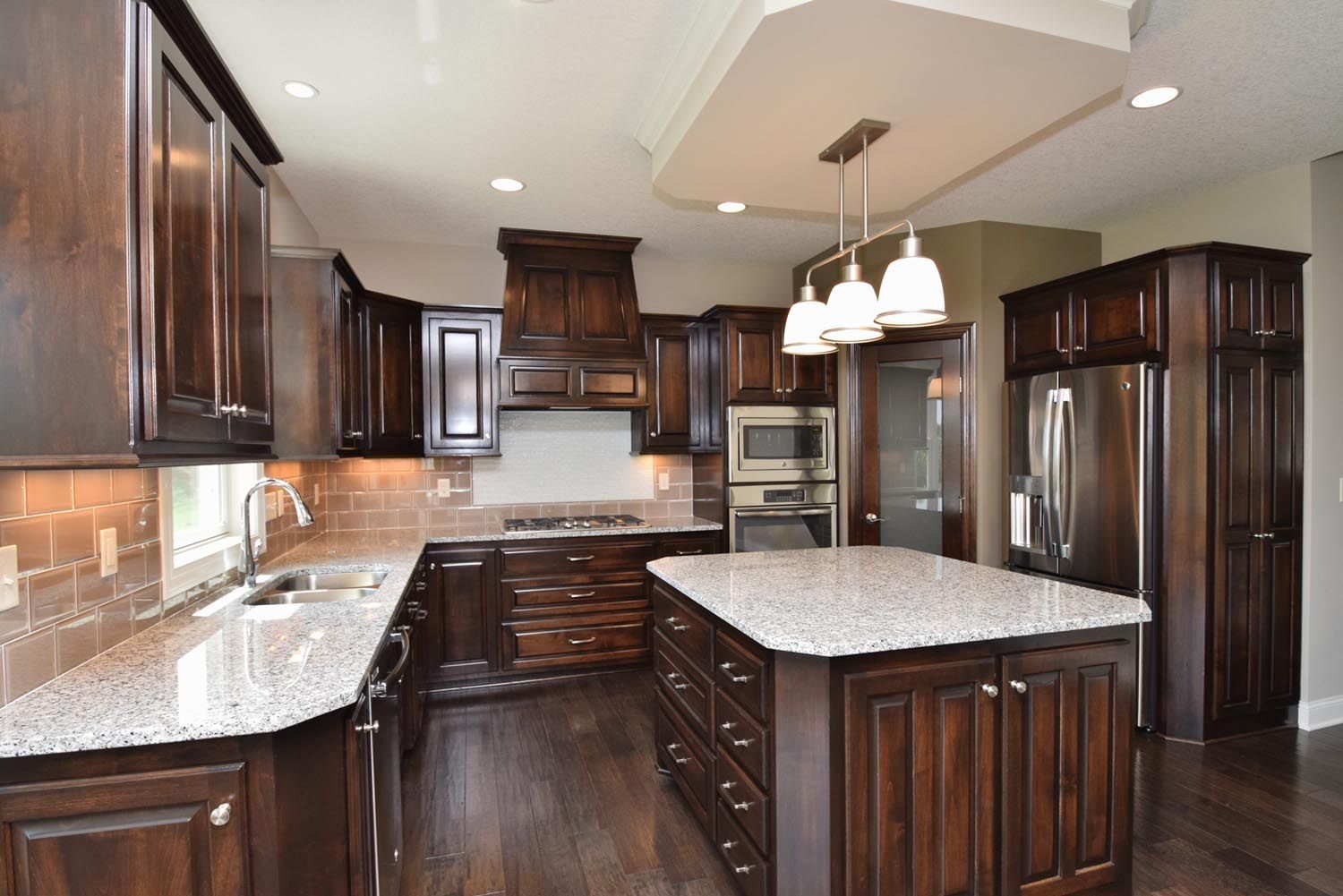 a kitchen with dark wood cabinets and granite counter tops