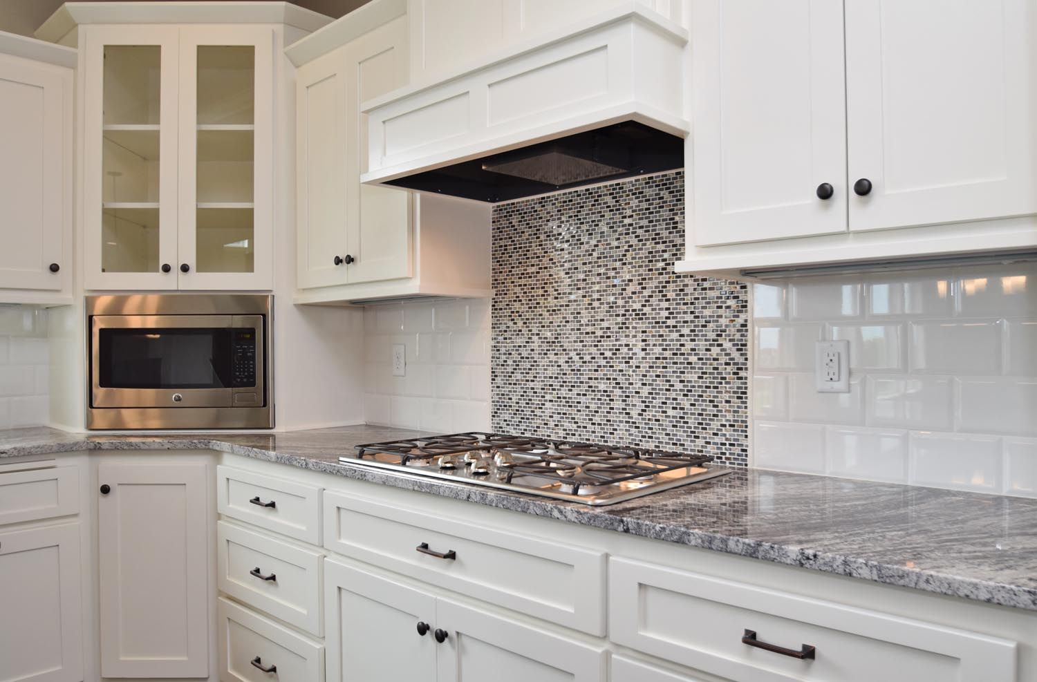 a kitchen with white cabinets and granite counter tops