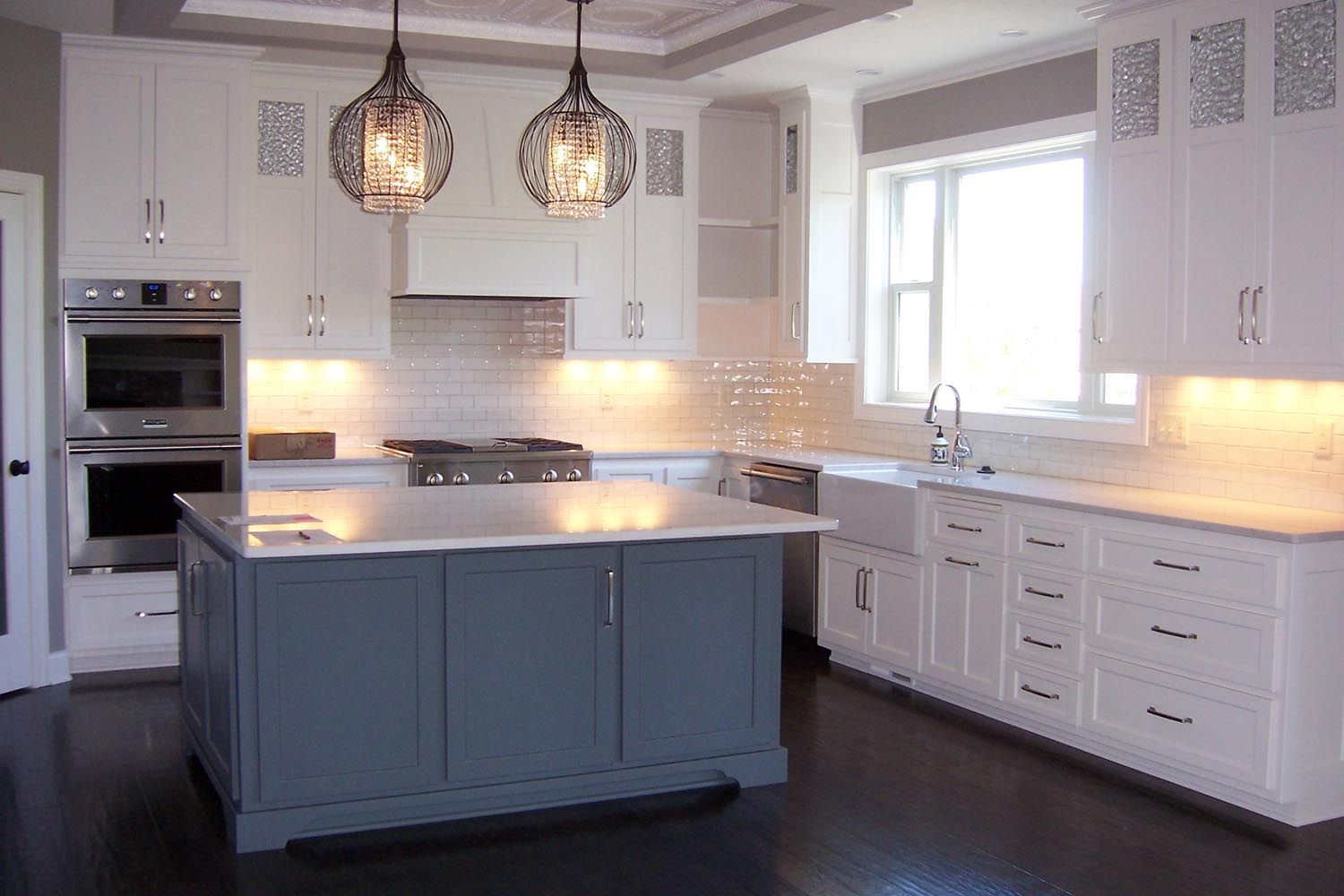 a kitchen with white cabinets and a large island in the middle