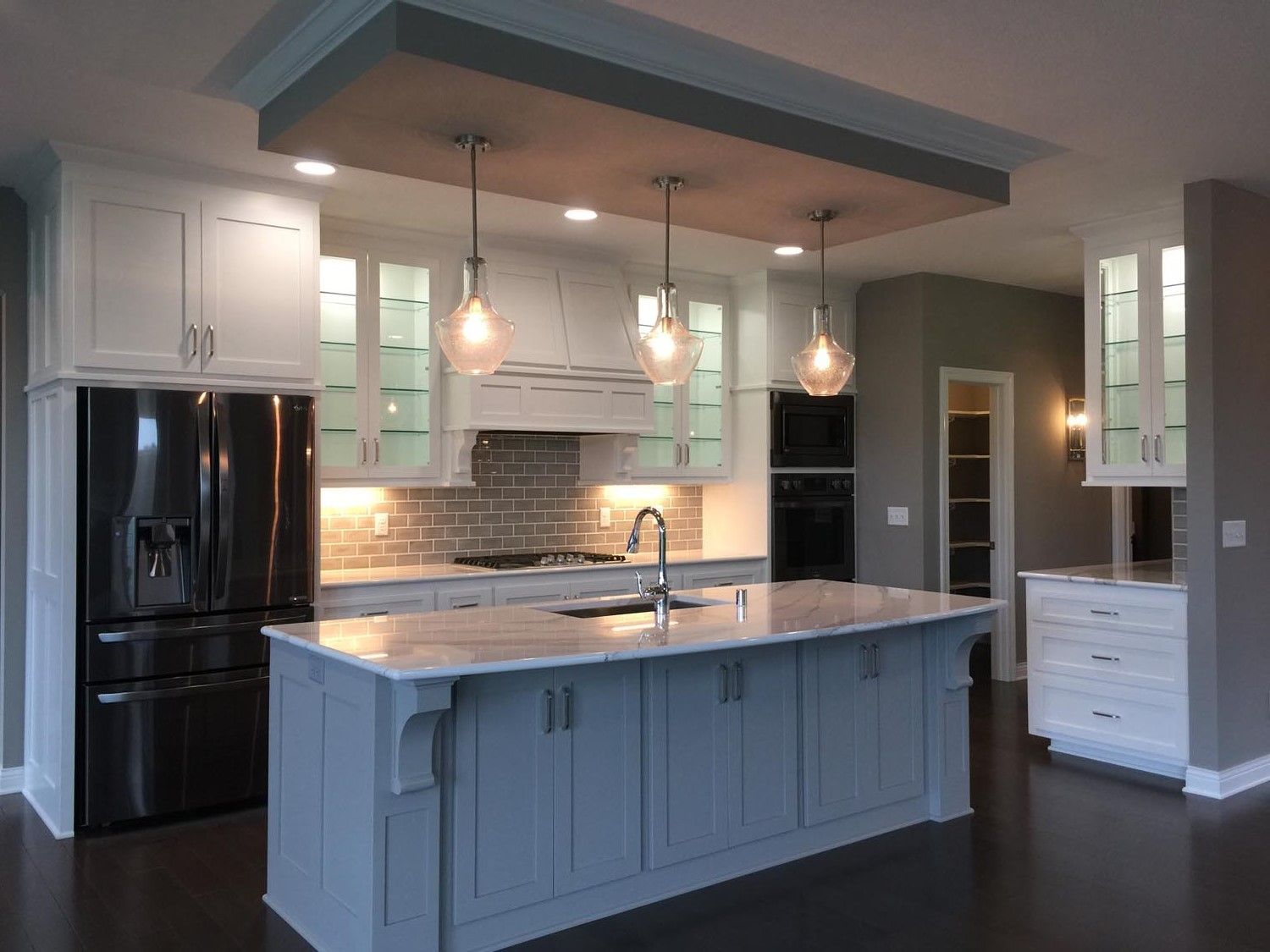 a kitchen with white cabinets and a large island in the middle