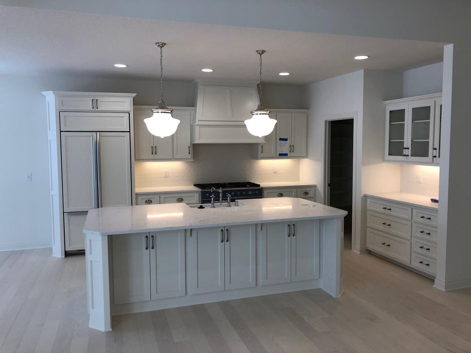 a kitchen with white cabinets and a large island in the middle
