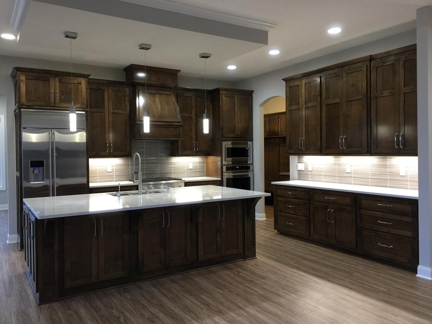 a kitchen with wooden cabinets, stainless steel appliances, and a large island