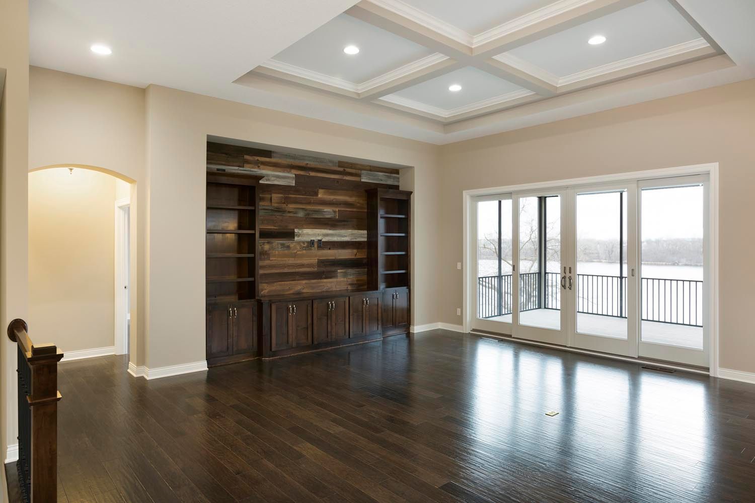 an empty living room with hardwood floors and lots of windows