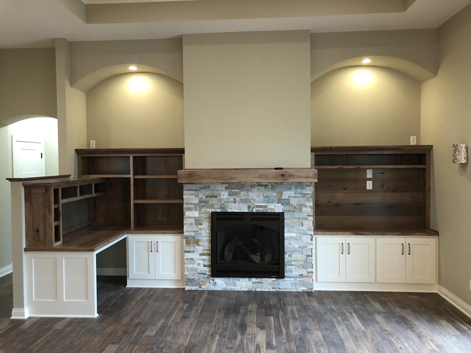 a living room with a fireplace and built-in shelves