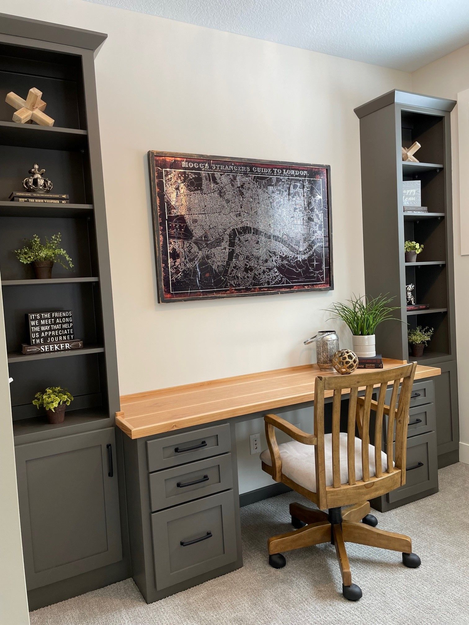 a home office with a desk, chair, shelves and a painting on the wall