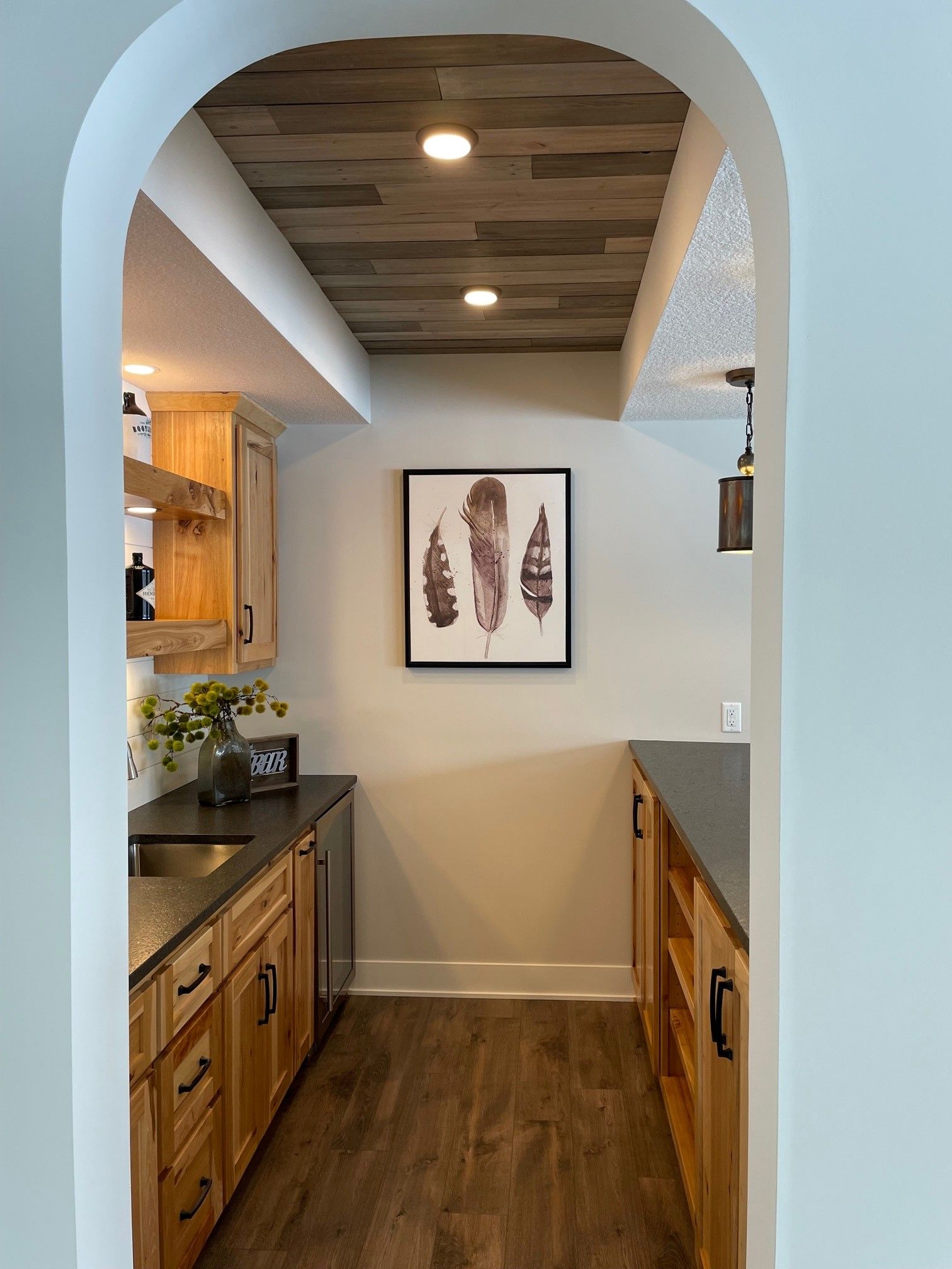 a kitchen with wooden cabinets and a picture of feathers on the wall