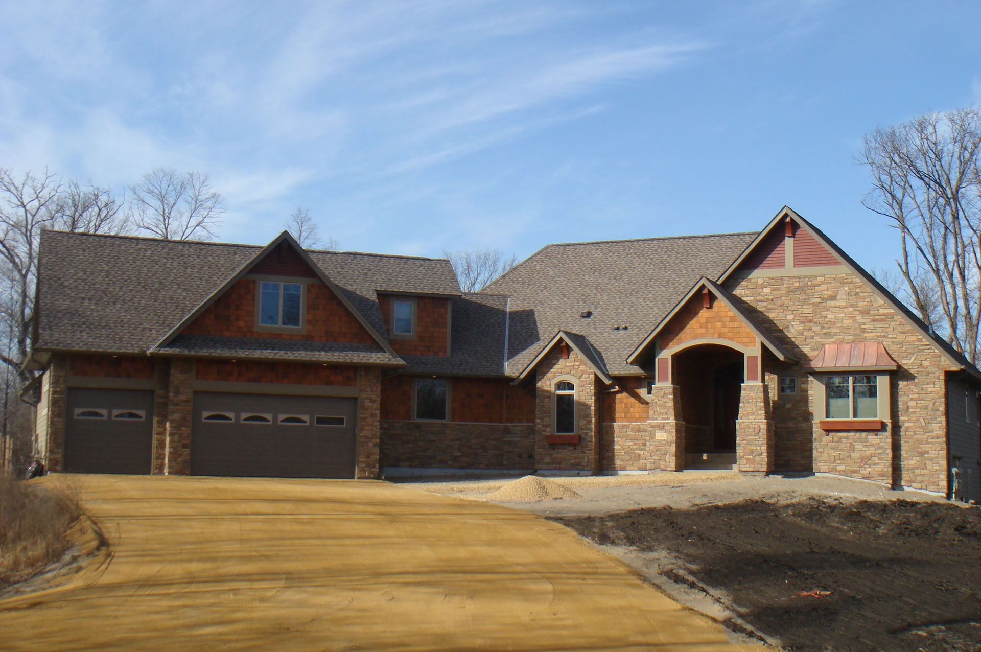 a large brick house with two garages and a dri