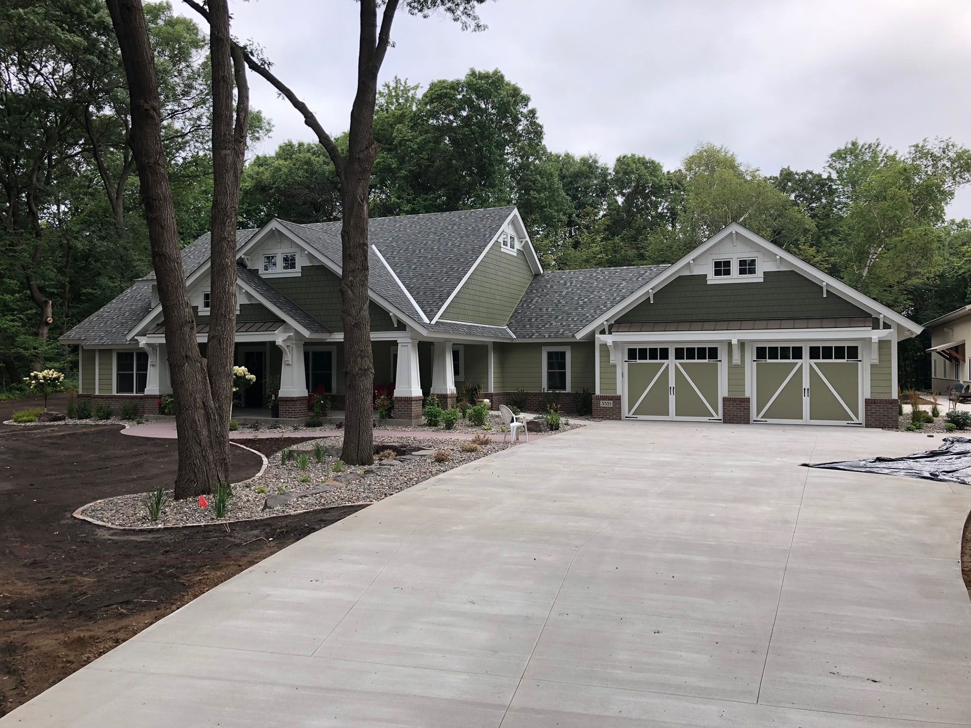 a large house with a driveway and trees in front of it
