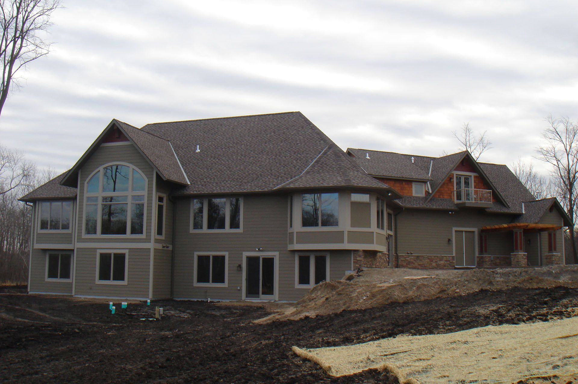 a large house with a lot of windows is sitting on top of a dirt hill