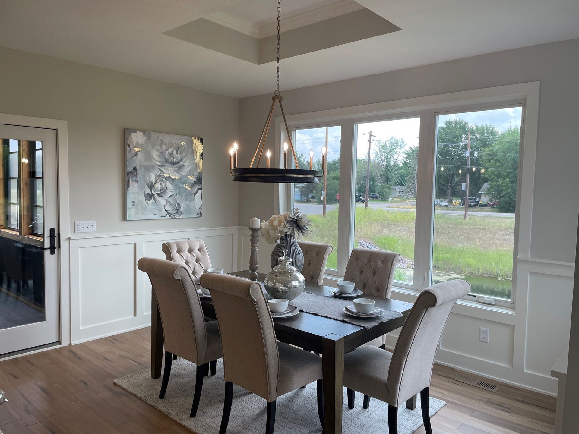 a dining room with a table and chairs and a chandelier hanging from the ceiling .
