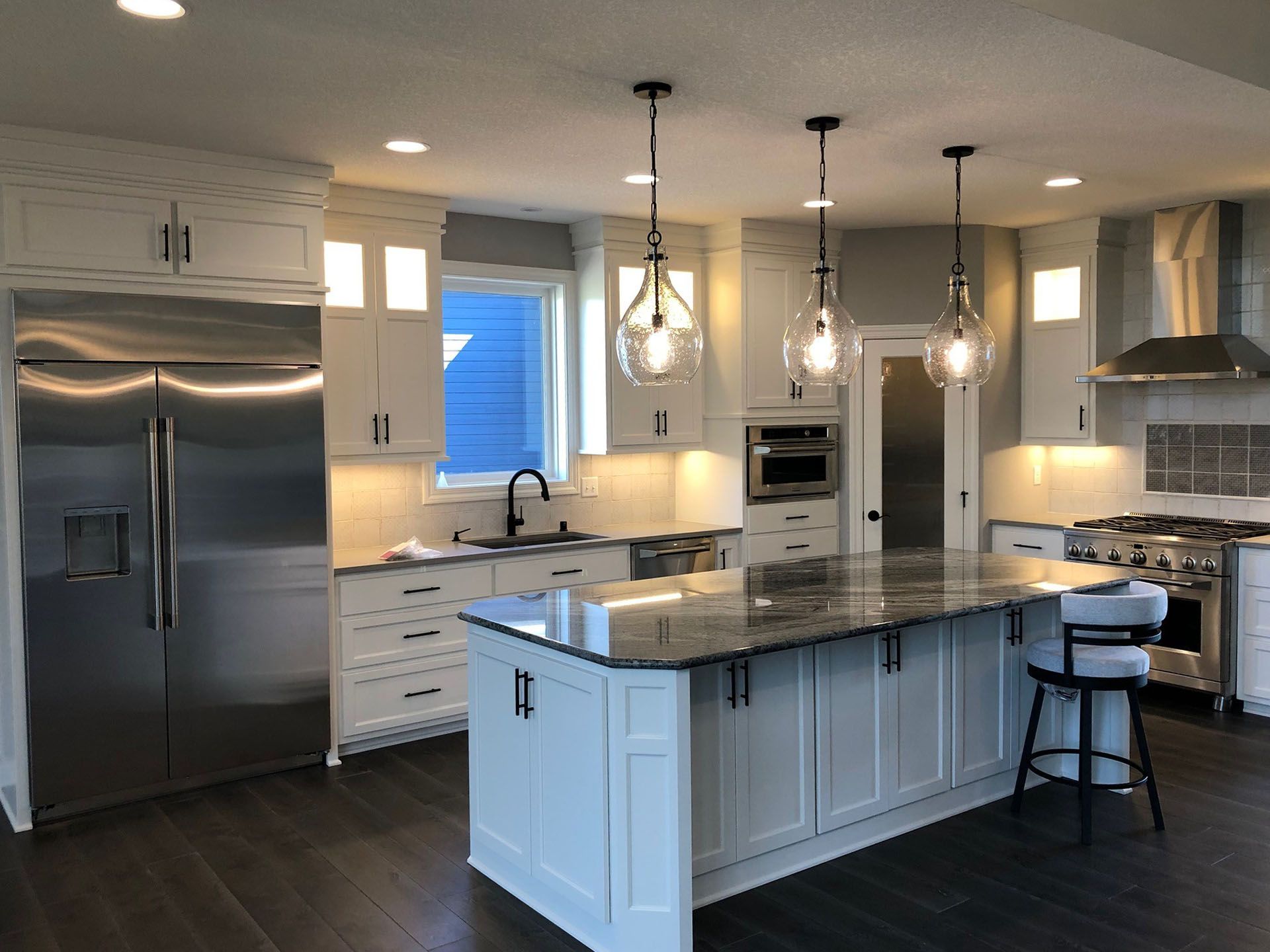 a kitchen with stainless steel appliances and white cabinets