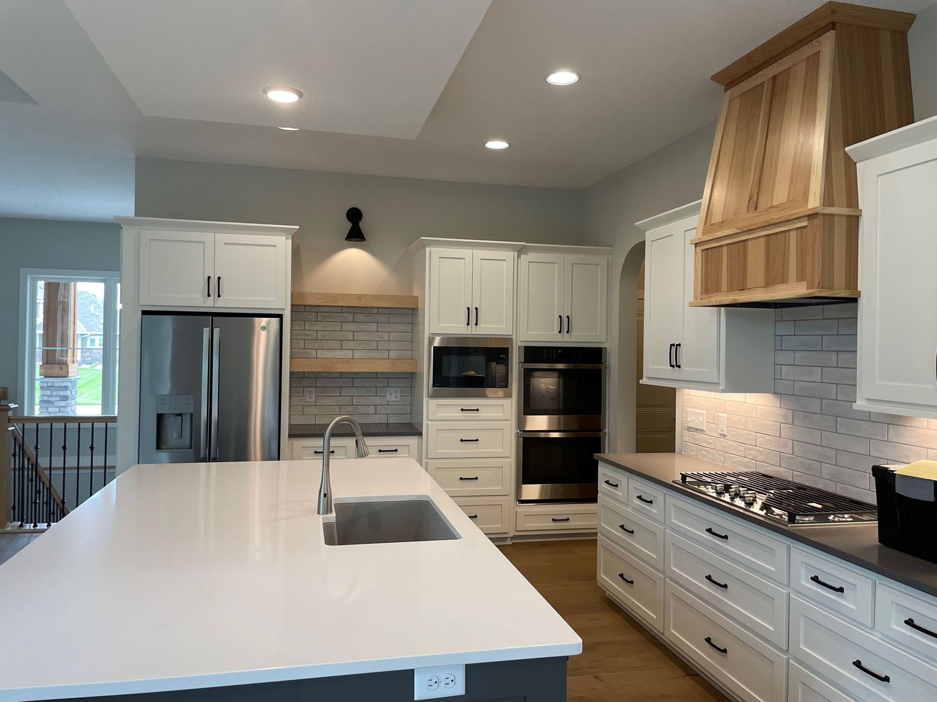 a kitchen with white cabinets , stainless steel appliances and a large island