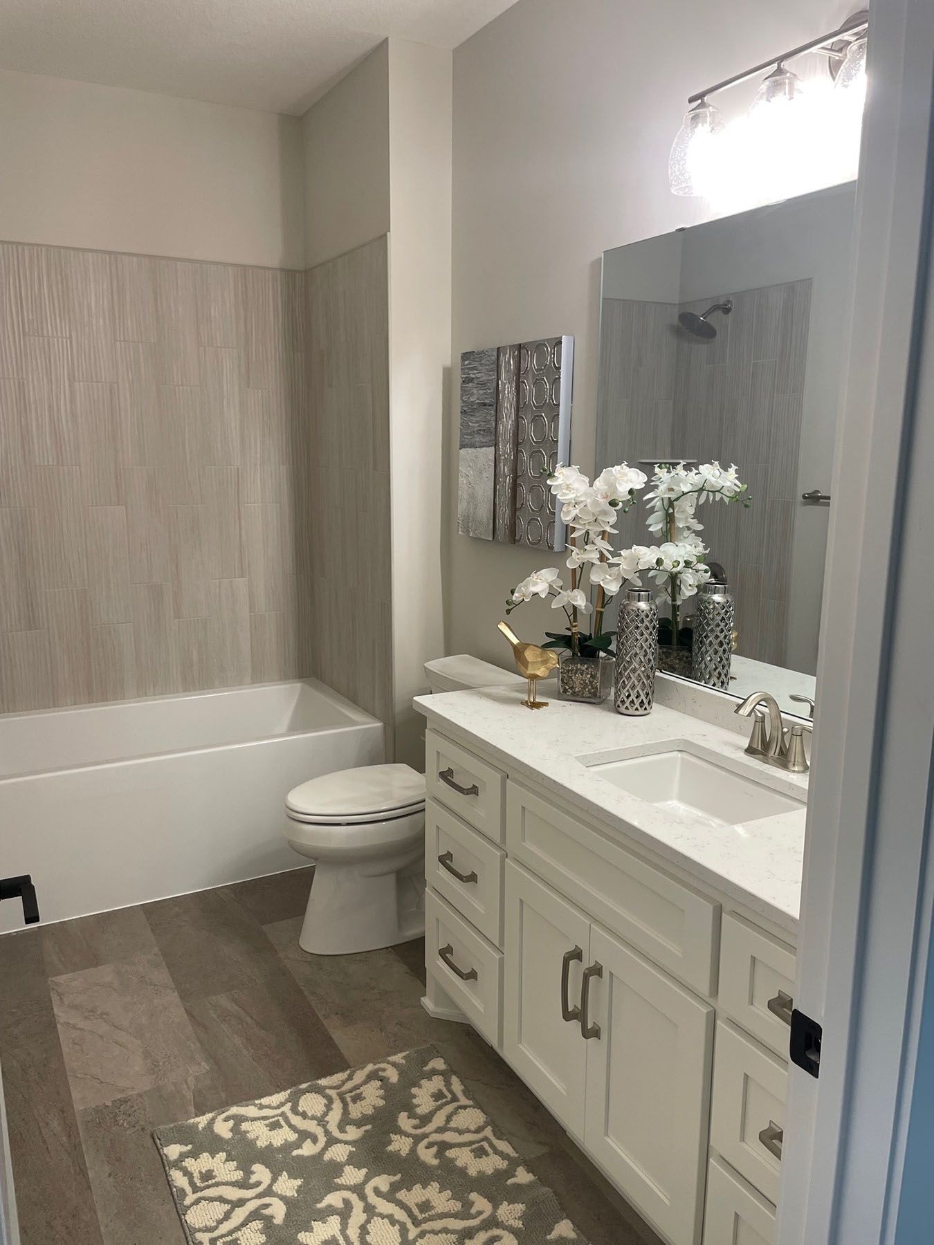 a bathroom with a sink, toilet, bathtub and mirror
