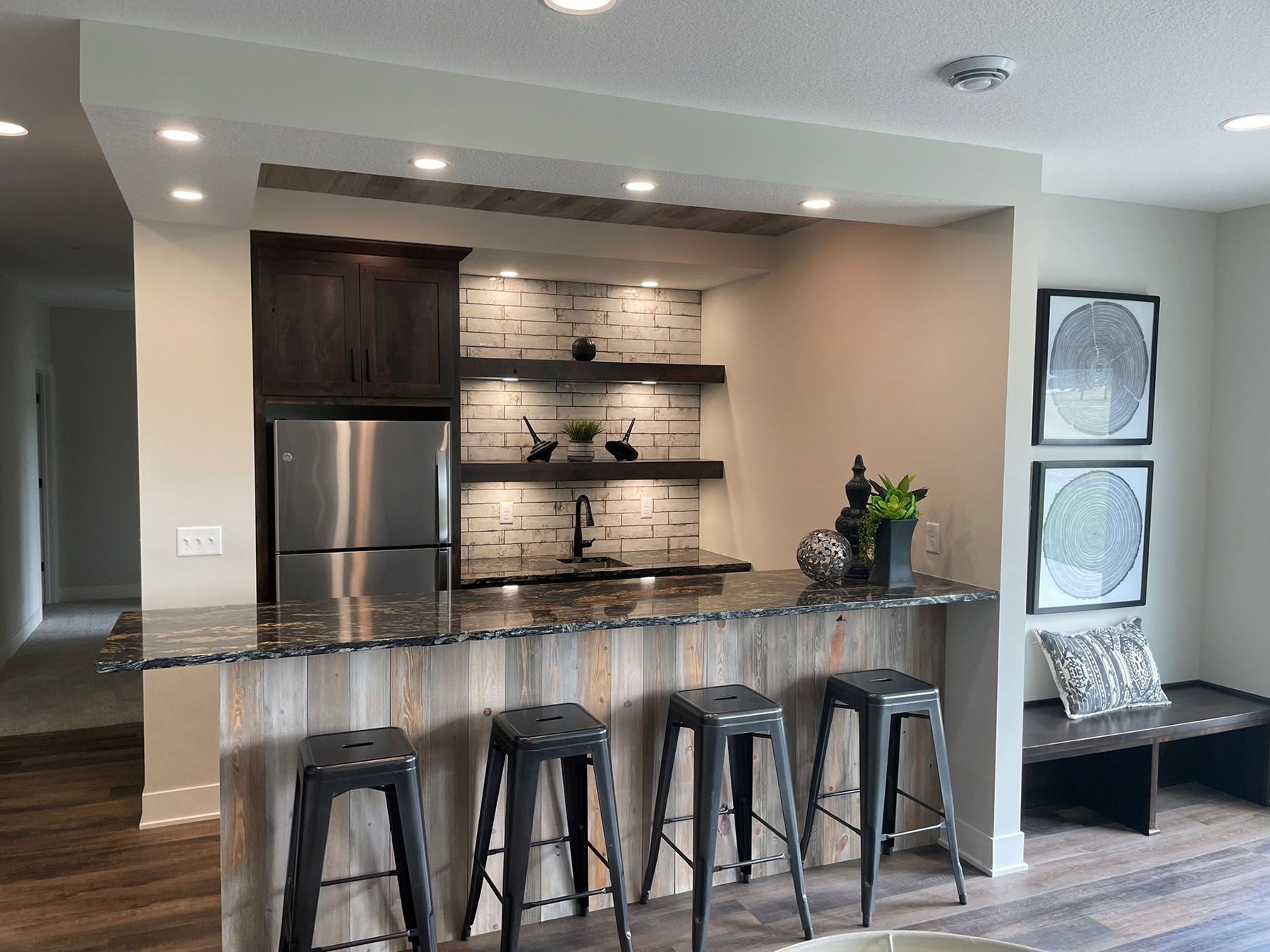 a kitchen with a bar and stools and a refrigerator