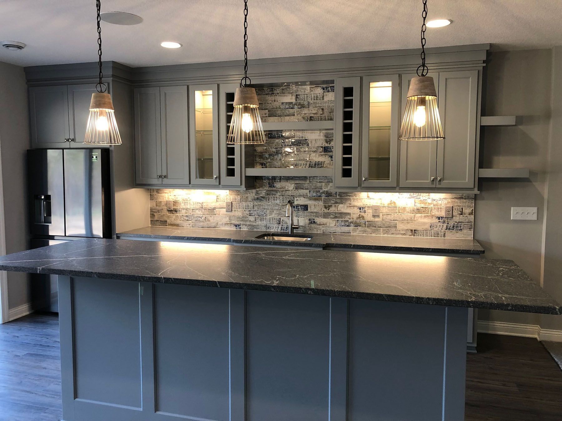 a kitchen with gray cabinets and granite countertops