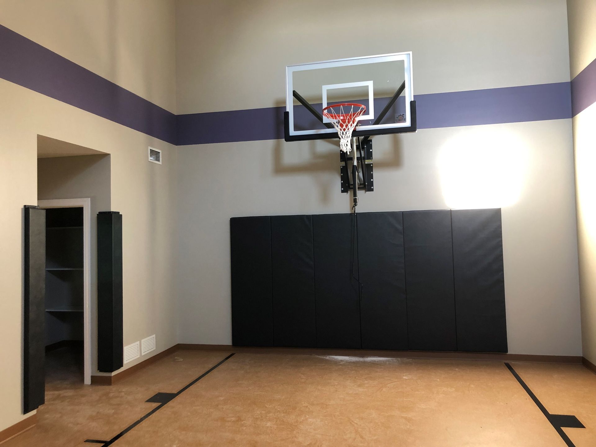 a basketball hoop in a room with purple stripes on the walls