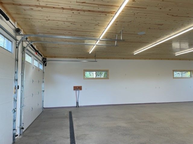 an empty garage with a wooden ceiling and white walls