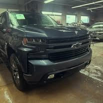 Dark blue Chevrolet pickup truck in a well-lit garage.
