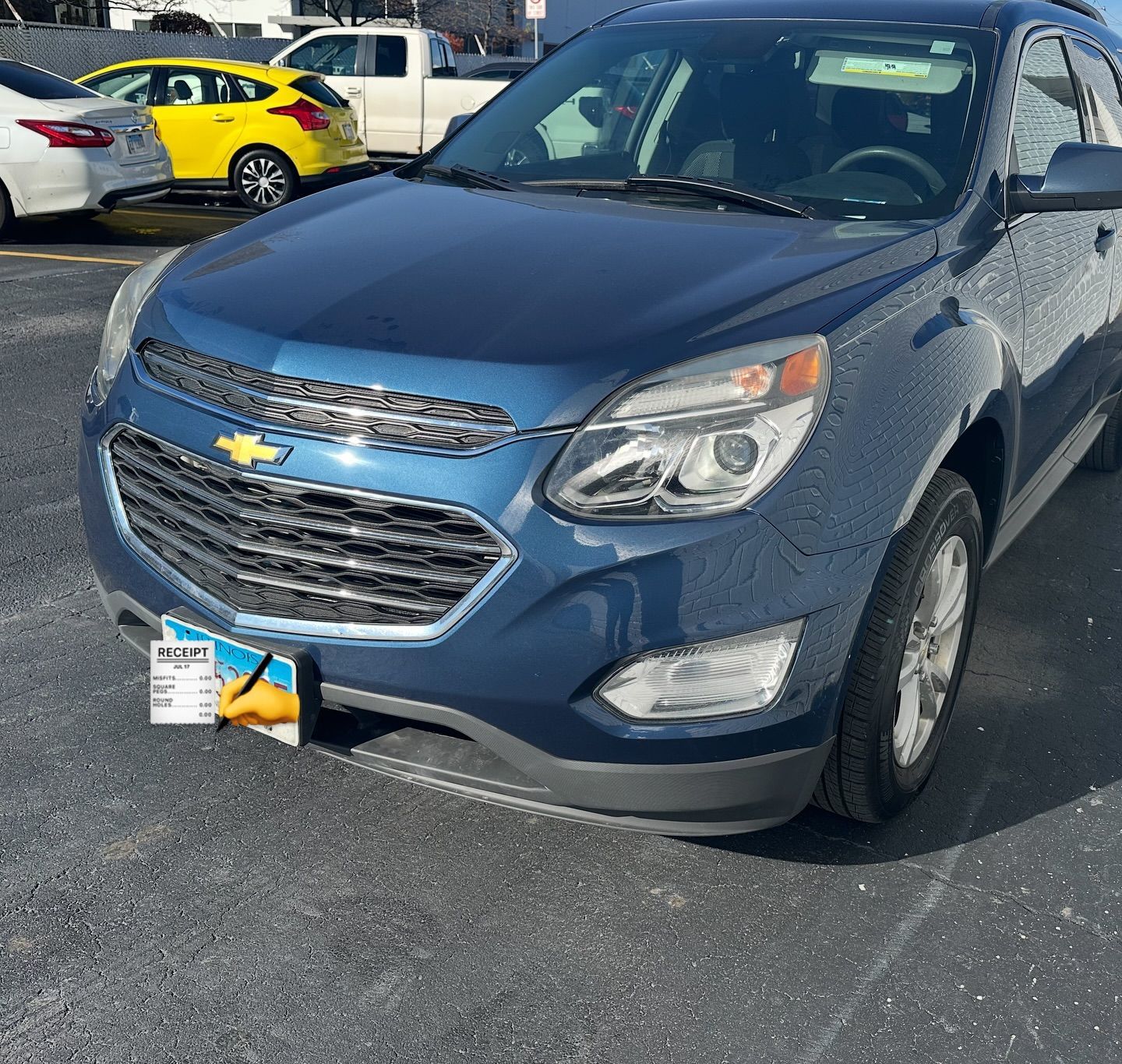 Blue Chevrolet Equinox SUV parked on asphalt.  A yellow car and a white truck are in the background.