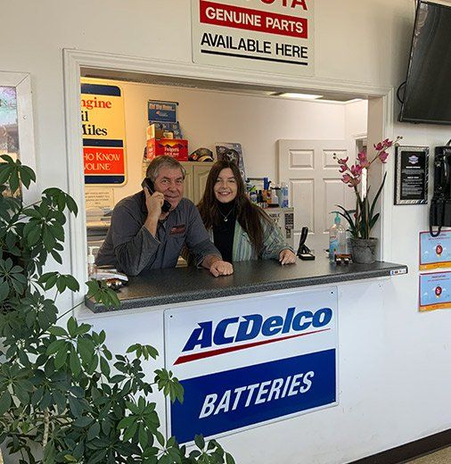 A man and a woman are sitting at a counter with a sign