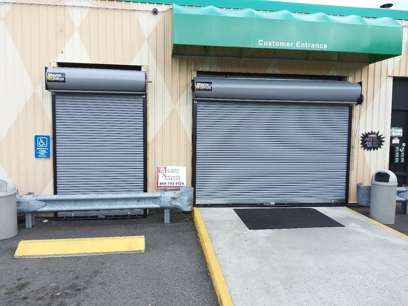 Closed storefront with two gray roll-up doors and a green awning