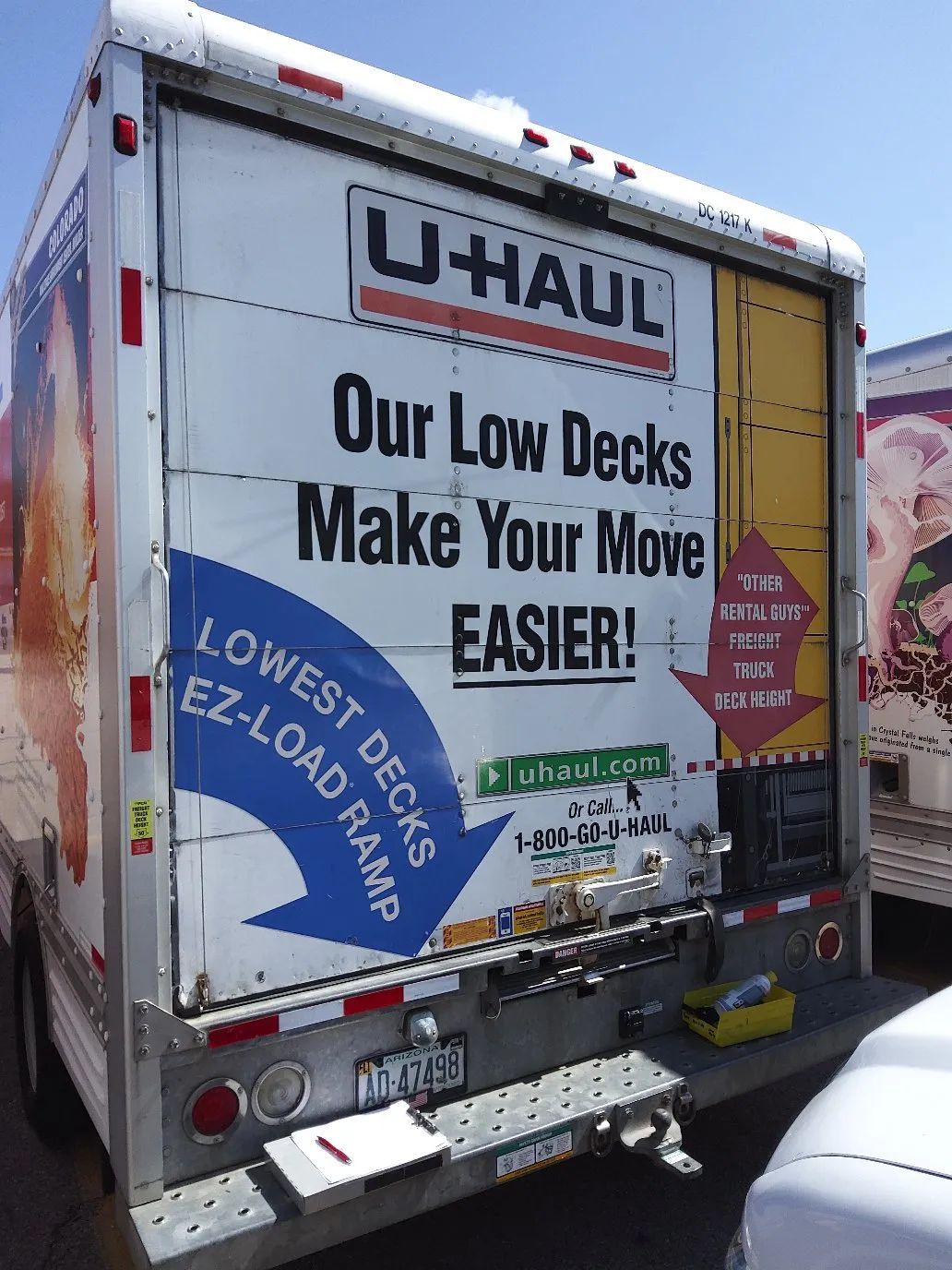 U-Haul moving truck rear with “Our Low Decks Make Your Move Easier” ad and colorful graphics