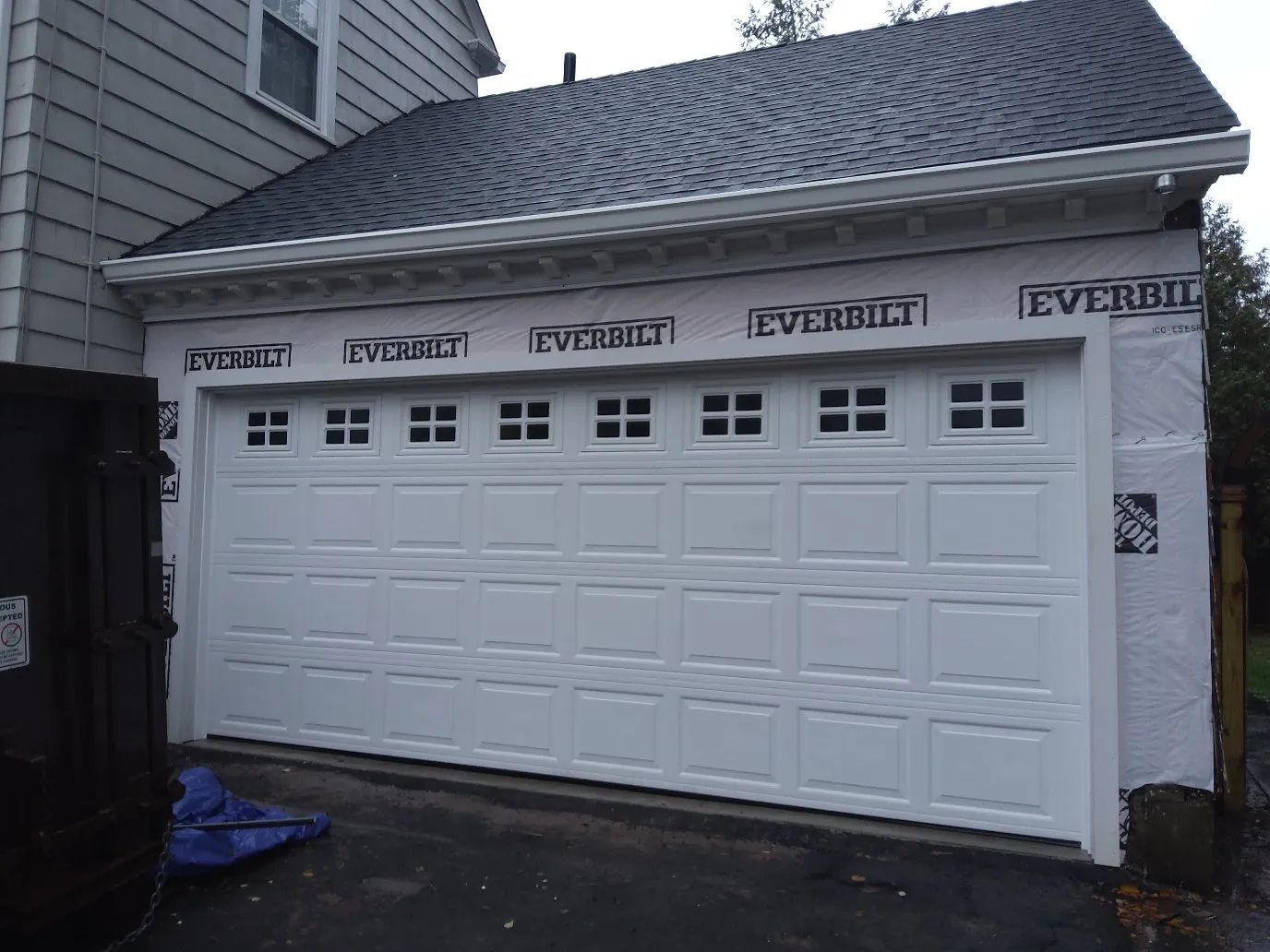 White double garage doors on a house exterior with small windows and Everbrite branding above.