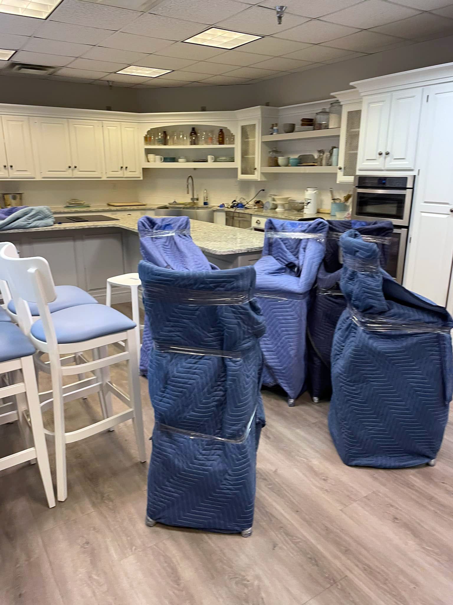 a kitchen with a lot of furniture wrapped in blue plastic