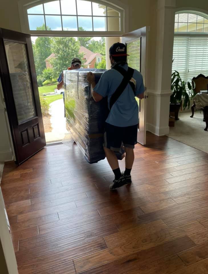 a man is carrying a refrigerator in a living room
