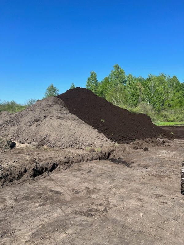 A large pile of dirt is sitting on top of a dirt field.