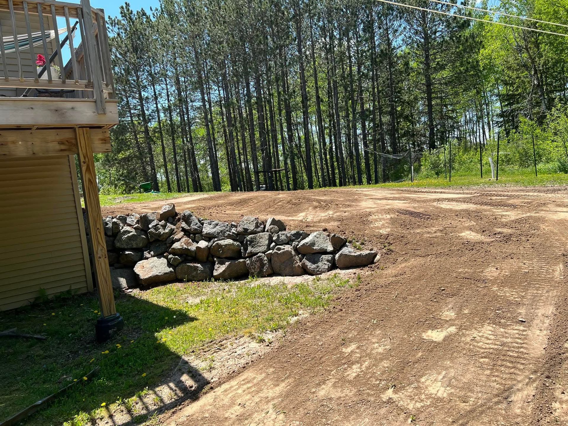 A dirt road leading to a house with trees in the background.