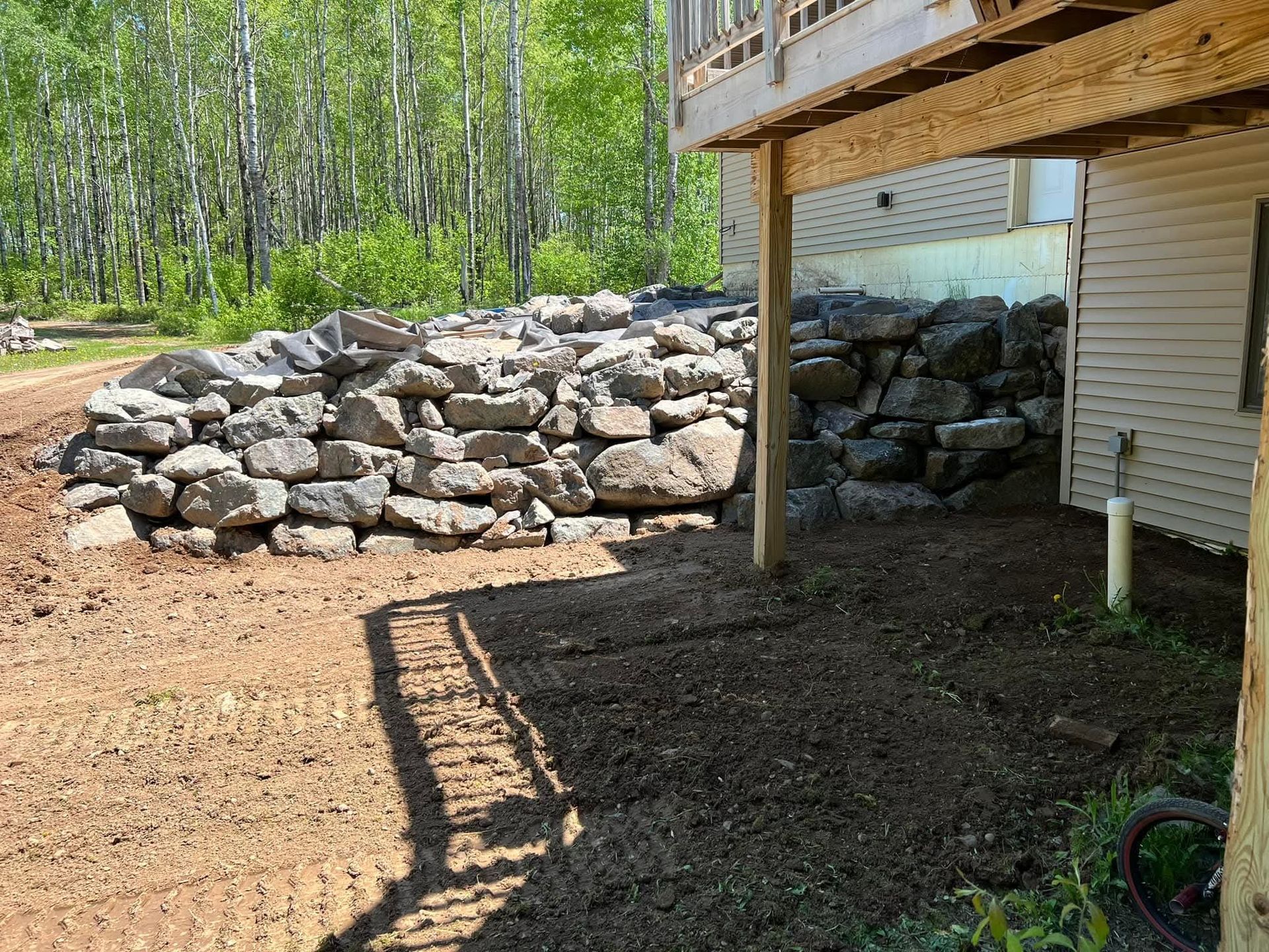 A large pile of rocks is in front of a house.