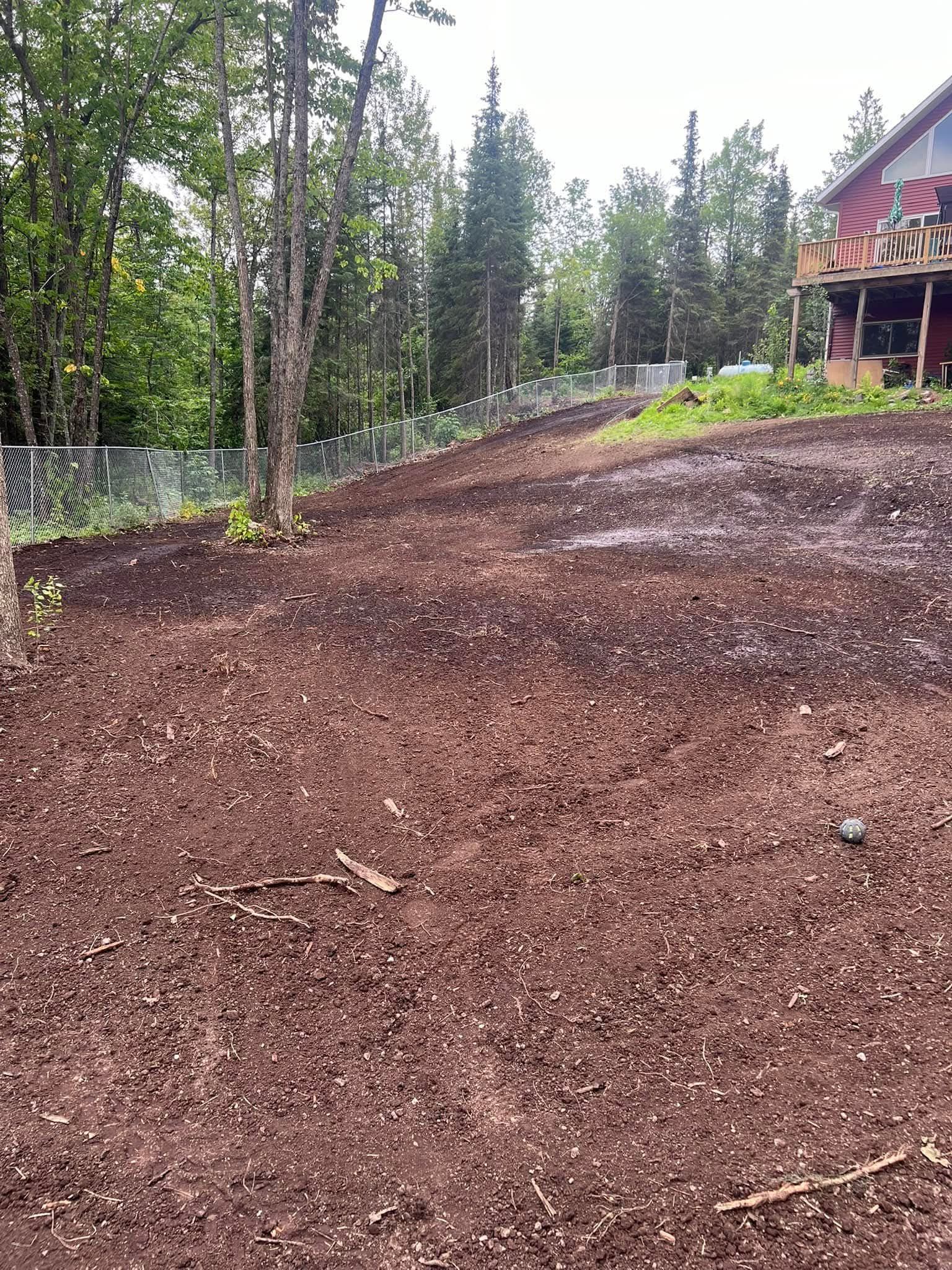A large pile of dirt is sitting in front of a house.