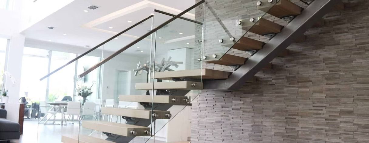 Modern staircase with glass railing and wooden steps in a well-lit interior.