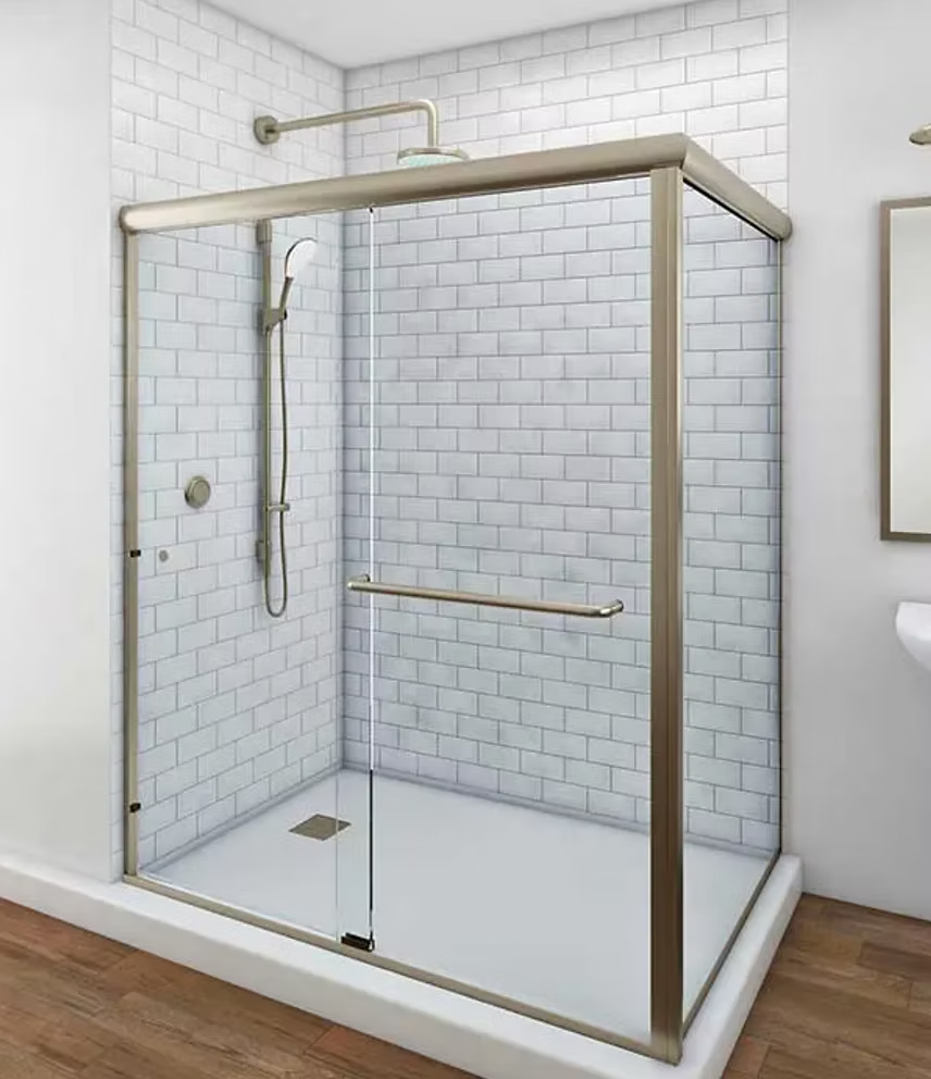 Shower with clear glass doors and brushed metal frame, white subway tile walls, and a low threshold.