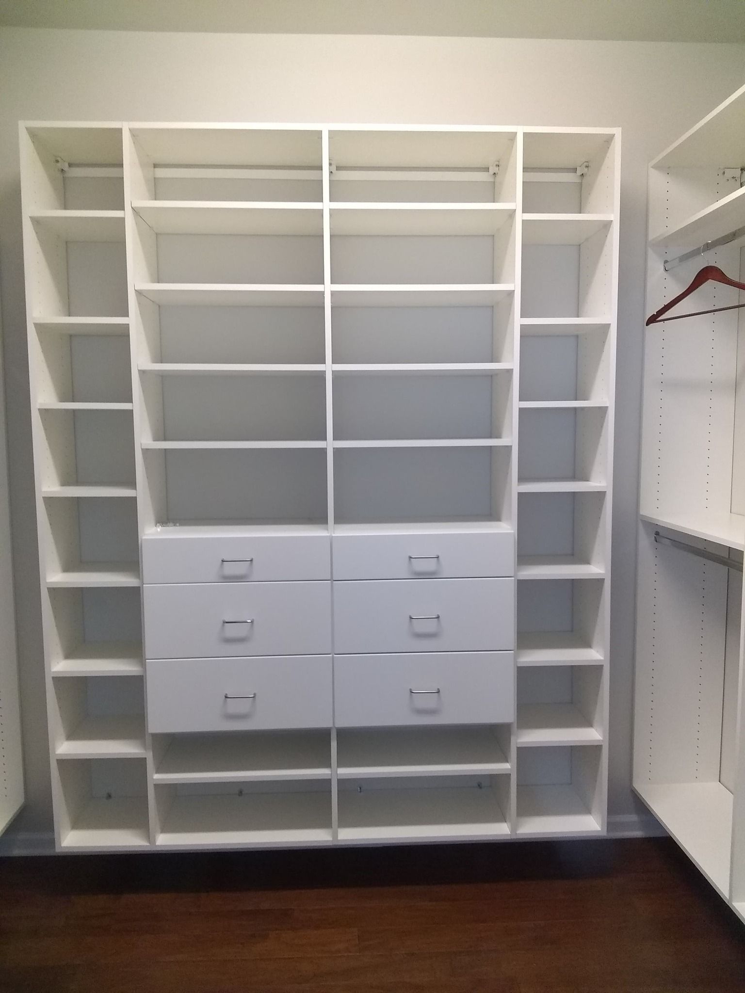 White closet organizer with shelves and drawers.