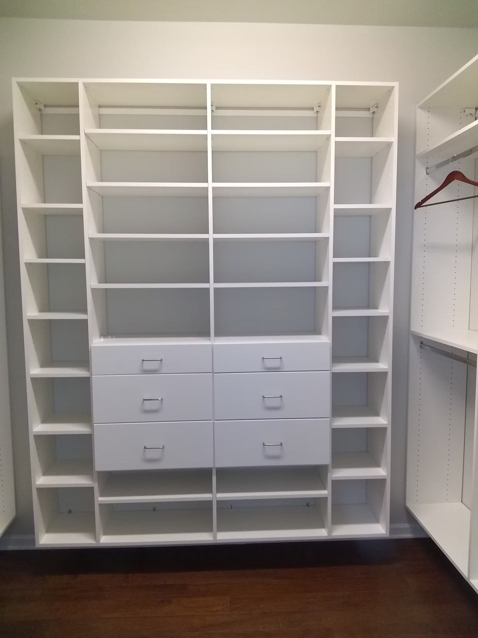White closet organization system with shelves and drawers.