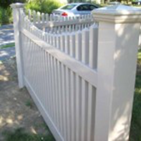 White picket fence along a sidewalk with a parked car in the background