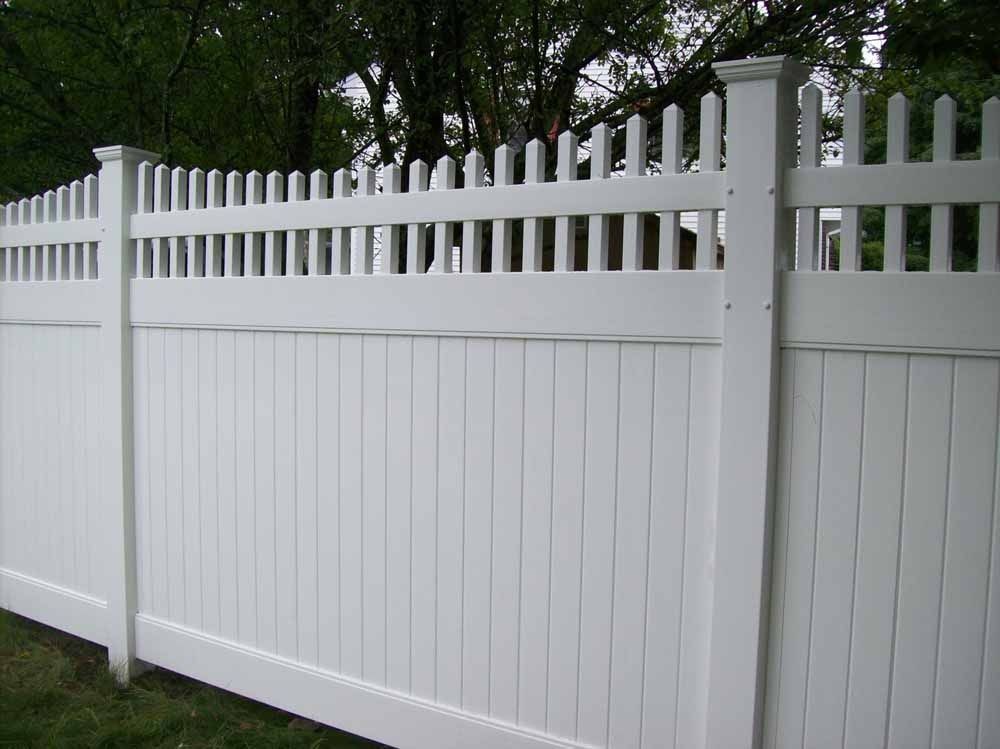White vinyl picket fence with a gate along a grassy yard