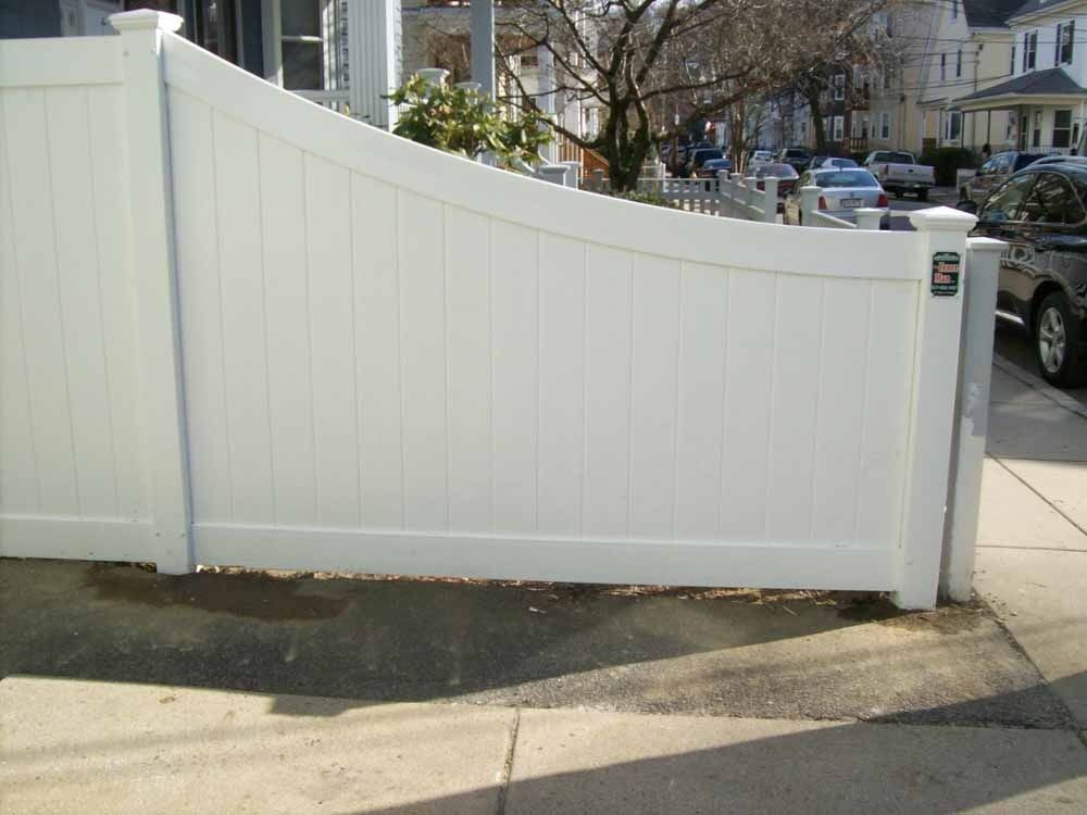 White curved wooden fence along a sidewalk on a residential street