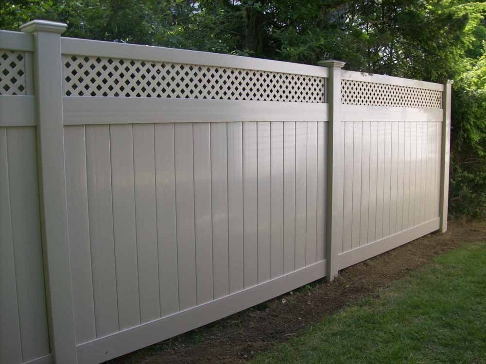 White vinyl privacy fence with lattice top along a grassy yard