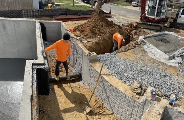 A group of construction workers are working on a concrete wall.