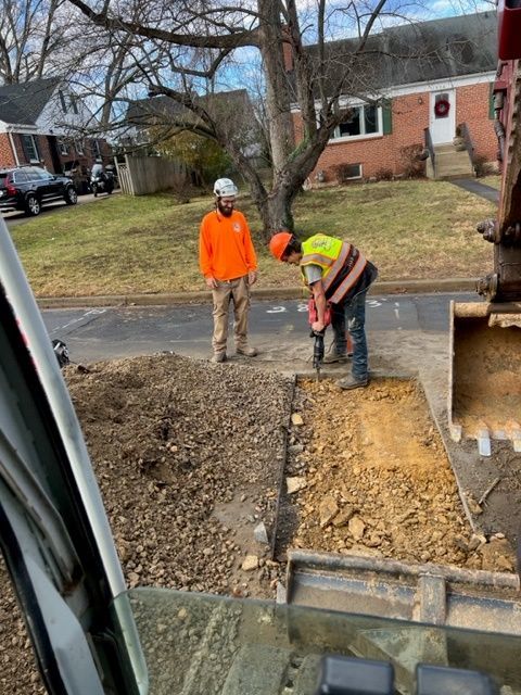 A man is using a drill to dig a hole in the ground