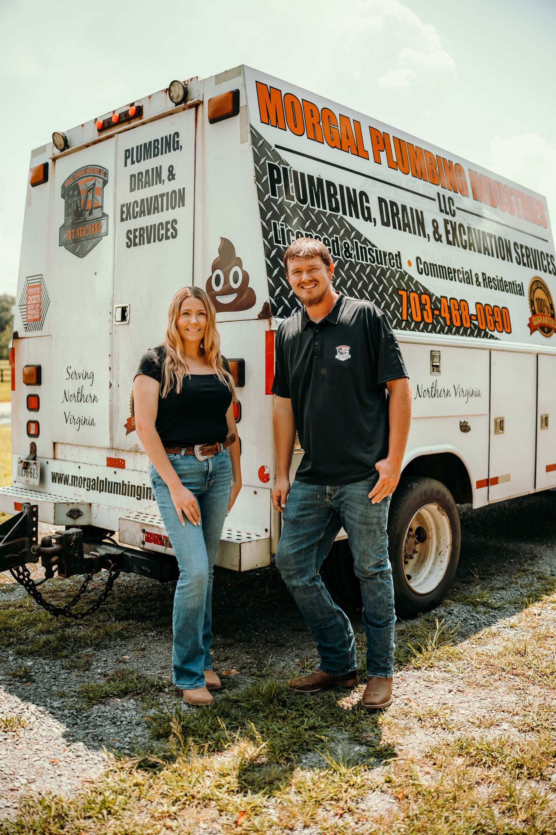 Woman and man in front of a plumbing truck. Woman smiles, in jeans. Man in a black shirt, smiles.