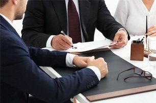 A group of business people are sitting at a table having a meeting.