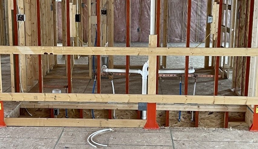 A wooden fence is surrounding a building under construction.