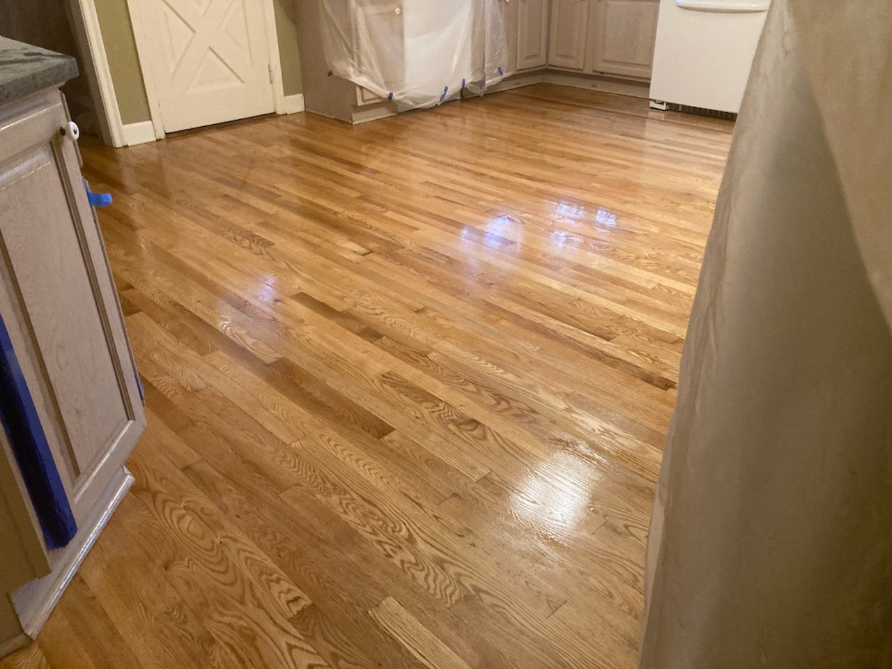 A kitchen with hardwood floors and white cabinets.